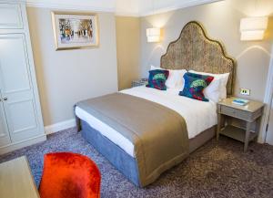 
a bedroom with a bed and a dresser at Arden House - Eden Hotel Collection in Stratford-upon-Avon
