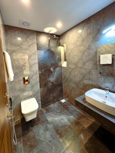 a bathroom with a sink and a toilet and a shower at Srishty Garden Resorts in Tenkāsi +20 photos
