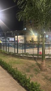 a fence with a palm tree in front of a building at Las Palmas Paraíso Ricaurte in Ricaurte