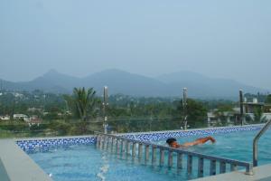 a man laying in a swimming pool at Blue Vista Residency in Kalpetta