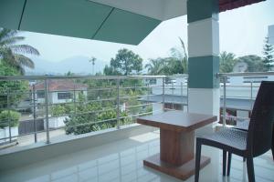 a balcony with a table and chairs and a view at Blue Vista Residency in Kalpetta