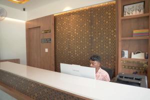 a woman sitting at a counter with a laptop at Blue Vista Residency in Kalpetta +41 photos