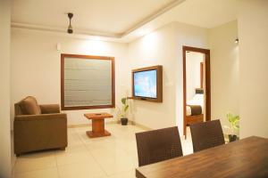 a living room with a table and a television at Blue Vista Residency in Kalpetta