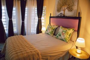 a bedroom with a large bed with two pillows at L a Grande deluxe in Benoni