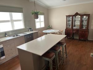 a kitchen with a counter and a table and chairs at Alvane Cottage in Goulburn