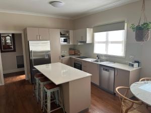 a kitchen with a sink and a refrigerator and a table at Alvane Cottage in Goulburn