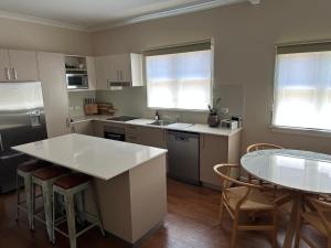 a kitchen with a sink and a table with chairs at Alvane Cottage in Goulburn +16 photos