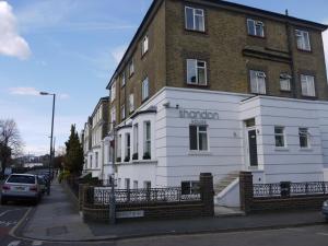 un edificio blanco y de ladrillo con un cartel. en Shandon Hotel, en Richmond upon Thames