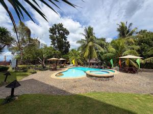 a swimming pool in a yard with a resort at Hotel Grand Luis in Dauis