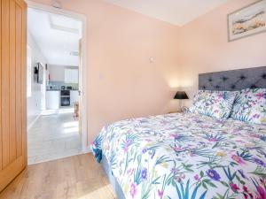 a bedroom with a bed with a floral bedspread at Jemmett Lodge in Kent