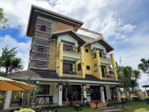 a yellow building with balconies on top of it at Hotel Grand Luis in Dauis