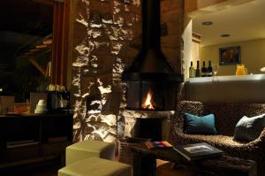 sala de estar con chimenea de piedra y sofá en Lirolay apartments en San Carlos de Bariloche