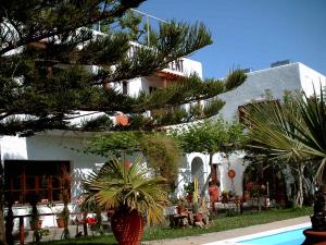 ein Baum vor einem Gebäude mit Pool in der Unterkunft Summer Lodge in Maleme