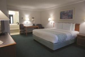 a hotel room with a large bed and a desk at Days Inn by Wyndham Georgetown in Georgetown