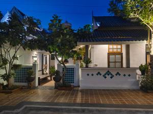 a house with a white fence and trees at Phu View Hideaway in Ban Kham Proi