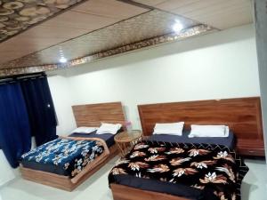two beds sitting next to each other in a room at Hotel Radha Krishana in Māna