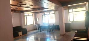 a room with a table and chairs and windows at Hotel Radha Krishana in Māna