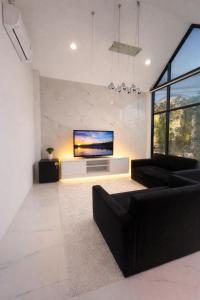 a living room with a flat screen tv on a wall at Pruksa Place Udon Thani in Udon Thani