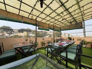 a patio with two tables and chairs on a roof at Rathore Stays in Udaipur