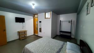 a bedroom with a bed and a television in it at Hab simplex in Cajamarca