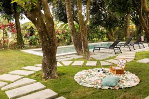 a blanket on the grass next to a pool at Altavida Lodge Brand New Studio with Pool in El Valle in Valle de Anton