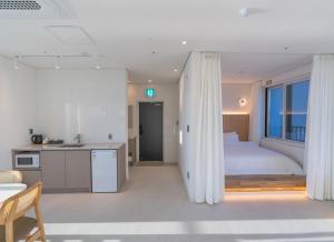 a bedroom with a bed and a kitchen and a room with a bed gmaxwell gmaxwell at 대천 아이오션 풀빌라 호텔 in Koryŏng