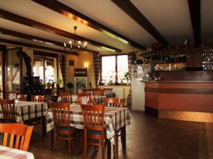 a restaurant with tables and chairs and a bar at Penzión Biela Voda in Veľká Lomnica