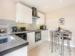 a kitchen with white cabinets and a counter top at Jemmett Lodge in Kent