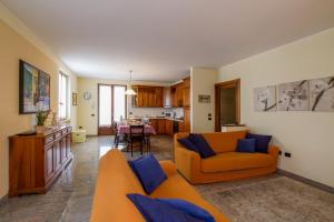 a living room with an orange couch and a kitchen at Appartamento Ai Prati in Lazise