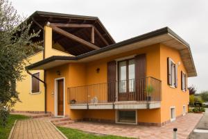 a yellow house with a balcony at Appartamento Ai Prati in Lazise