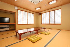 a living room with a table and a flat screen tv at Fukuichi in Nambu