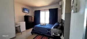 a bedroom with a blue bed and a window at Umkomaas Lodge in Umkomaas