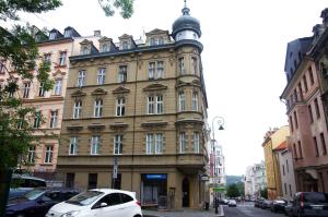 un bâtiment avec une tour d'horloge dans une rue de la ville dans l'établissement Apartment on Krale Jiriho 2, à Karlovy Vary