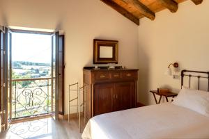 a bedroom with a bed and a balcony with a view at Casa Remedios in Villarquille
