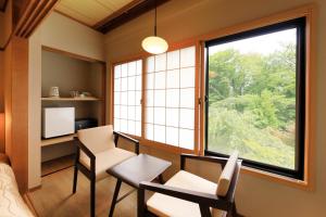 a room with a window and a desk and chairs at ゆるり箱根withDOGS in Hakone
