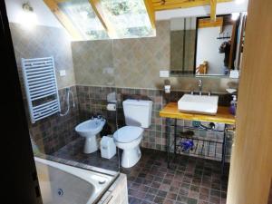La salle de bains est pourvue de toilettes, d'un lavabo et d'une baignoire. dans l'établissement Cabañas Rukayen, à Villa La Angostura