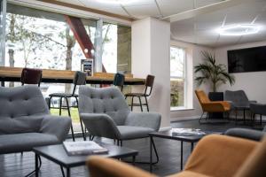 a waiting room with chairs and tables and a counter at Ramada London Stansted Airport in Stansted Mountfitchet