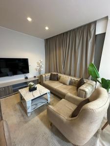 a living room with two couches and a flat screen tv at Fully Furnished Hotel Studio for Rent in ZED Towers Sheikh Zayed in Sheikh Zayed