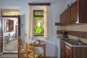 a kitchen with a sink and a table and a window at Erato Apartments in Lindos