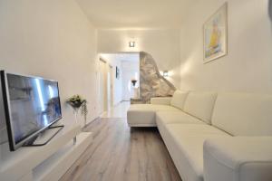 a living room with a white couch and a flat screen tv at Villa Sarah in Supetar