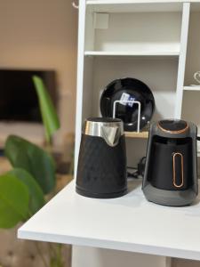 two black and silver coffee mugs sitting on a shelf at Fully Furnished Hotel Studio for Rent in ZED Towers Sheikh Zayed in Sheikh Zayed