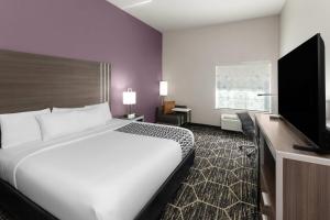 a hotel room with a bed and a flat screen tv at La Quinta by Wyndham Boutte in Boutte