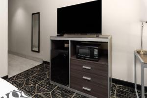 a entertainment center with a flat screen tv on a wall at La Quinta by Wyndham Boutte in Boutte