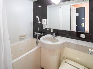 a bathroom with a sink and a toilet and a mirror at Comfort Hotel Maebashi in Maebashi +29 photos