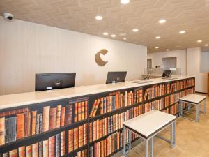 a library with a long shelf of books at Comfort Hotel Maebashi in Maebashi