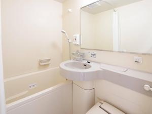 a white bathroom with a sink and a mirror at Comfort Hotel Hikone in Hikone +32 photos