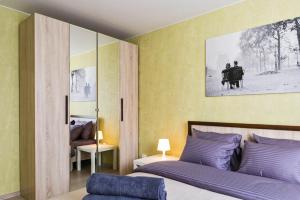 1 dormitorio con 1 cama y una pintura en la pared en Lux Apartments, en Moscú