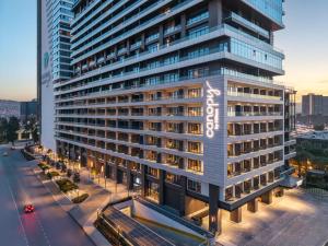 a tall building with a sign on the side of it at Canopy By Hilton Izmir Bomonti in İzmir