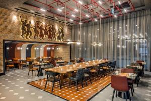a dining room with tables and chairs and a wall at Canopy By Hilton Izmir Bomonti in İzmir