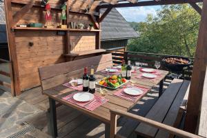 a wooden table with wine bottles and a bowl of fruit at Chalupa Štikov v Podkrkonoší in Nová Paka